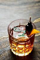 Alcoholic drink. A cocktail with elite alcohol on dark black background photo