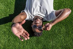 Man lying down relaxing in lush green field photo