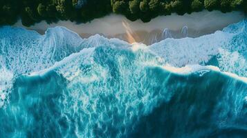 Amazing aerial view of emerald green sea, small white sand beach with green forest peaceful and white foamy waves crashing on the shore on a sunny day. photo