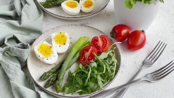 färsk vår sallad med kokt ägg, sparris, och tomater på en ljus dag video