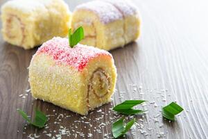 Various flavour swiss roll cake on wooden table. photo