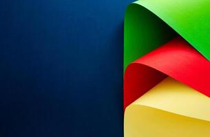 Vibrant red, yellow and green aper shapes contrasted against a blue background. photo