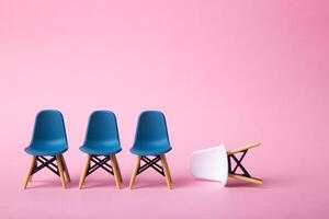 Row of white chairs and a white one falling down. Business concept. photo