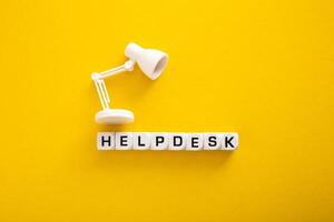 Word of Helpdesk with Table lamp on yellow background photo