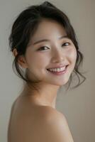 Portrait of a smiling Asian woman. Elegant portrait of a young Asian woman with a radiant smile, looking over her shoulder in a soft, natural light setting. photo