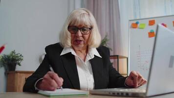 Sénior personnes âgées affaires Bureau femme elearning en ligne l'écriture Remarques de ordinateur portable, vivre séminaire en ligne en ligne video