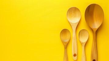 Wooden spoons on yellow background. Assortment of wooden spoons arranged neatly on a vibrant yellow background, emphasizing simplicity and utility in kitchenware. photo