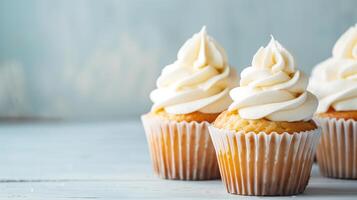 Vanilla Cupcakes with Creamy Frosting. Close-up of vanilla cupcakes topped with swirls of creamy white frosting, set against a soft blue background. photo