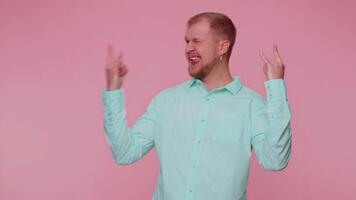 Overjoyed happy man showing rock n roll gesture by hands, cool sign, shouting yeah with crazy face video