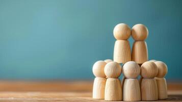 Wooden figures assembled in tiers. Wooden figurines stacked in two tiers against a blue backdrop. . photo