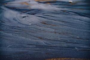 dark sand texture on the beach photo