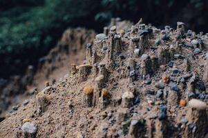 piles of sand exposed to rainwater look like miniature cliffs and mountains photo