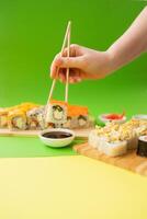 Sushi delivery. Set of rolls in a disposable box on a black background. Top view photo