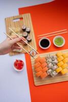 Sushi delivery. Set of rolls in a disposable box on a black background. Top view photo