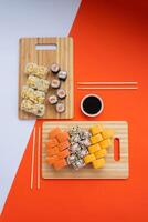 Sushi delivery. Set of rolls in a disposable box on a black background. Top view photo