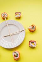 Sushi delivery. Set of rolls in a disposable box on a black background. Top view photo