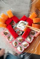 Sushi delivery. Set of rolls in a disposable box. Top view photo