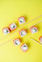 Sushi delivery. Set of rolls in a disposable box on a black background. Top view photo
