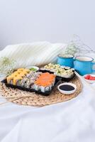 Sushi delivery. Set of rolls in a disposable box on a black background. Top view photo
