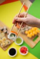 Sushi delivery. Set of rolls in a disposable box on a black background. Top view photo