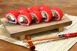 Sushi delivery. Set of rolls in a disposable box on a black background. Top view photo