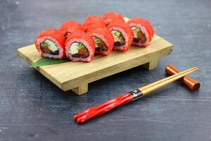 Sushi delivery. Set of rolls in a disposable box on a black background. Top view photo