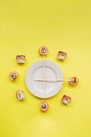 Sushi delivery. Set of rolls in a disposable box on a black background. Top view photo