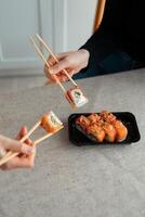 Sushi delivery. Set of rolls in a disposable box on a black background. Top view photo