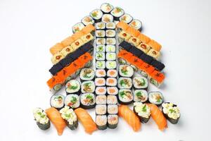 Sushi delivery. Set of rolls in a disposable box on a black background. Top view photo