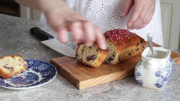 Close-up of woman in white dress putting cake slices on saucer in kitchen. video