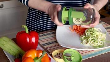 Woman cutting vegetable with slicer in kitchen. Plate, paper and modern vegetable cutter. video