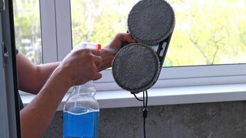 Glass cleaner and mirror are applied to a sponge from a robotic window cleaner. video