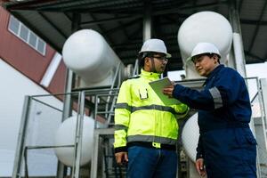 Two men wearing safety gear working in a warehouse. One man showing the other something on a digital tablet. photo