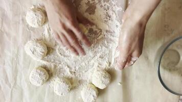 Female hands sculpting cottage cheese pancakes on cuisine table. Arms of young woman preparing tasty breakfast on desk. Process of making cheesecakes in home kitchen. Healthy food concept. video