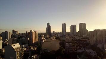 Antenne Stadt Aussicht beim Dämmerung. Drohne Schuss von städtisch Horizont mit Gebäude, Wolkenkratzer im Morgen Sonnenlicht. Stadtbild von Buenos Aires mit Panorama- die Architektur, steigend Sonne Über Horizont. video