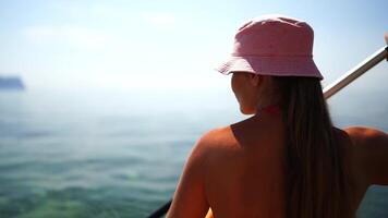 A woman in a pink hat is holding a paddle and looking out at the water. Scene is peaceful and serene, as the woman is enjoying a leisurely paddle on the water. video