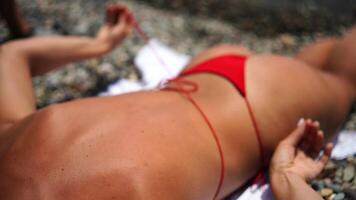 kvinna tar röd bikini av på strand för solbränna, lady strippning Semester baddräkt med rosett i sträng. roligt och koppla av, sexig modell lossa simning kostym behå, Lycklig kvinna i badkläder på semester video