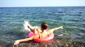 Summer vacation happy woman floats on an inflatable donut mattress, pink swim ring. Summer travel holidays vacation on the sea. video