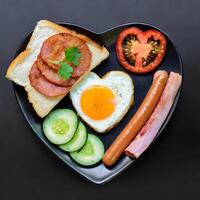 bread bacons sausage fried egg cucumber and tomato served for breakfast photo