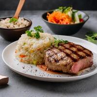 fresh grilled beef steak with fried rice and vegetable salad photo