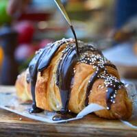 croissant full of chocolate stuff and stuffing is melting from it photo