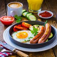 breakfast fried eggs sausages zucchini and sweet peppers photo