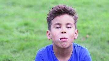 six ans garçon dans une bleu T-shirt avec une sale visage farci tout le Pâtes dans le sien bouche avec plaisir, mâche avec le sien bouche complet, il a une lot de amusant, video