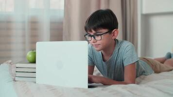 Home Isolation, Online Learning, Remote Work, New Education. A boy during online learning lies on the bed at home video