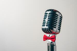 Elegant vintage microphone with red bowtie on white background exudes charm photo