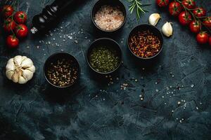 Dark stone kitchen background with spices, herbs and kitchen utensils. Free space for text. Top view. Rustic style. photo