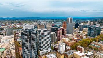 Downtown of Portland, Oregon, the USA with high-rise architecture. Twilight view of the city with mountain silhouettes at backdrop. photo