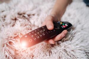 Watching TV and using remote controller photo