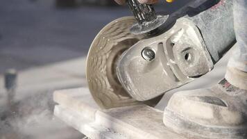 A man is using a grinder to cut a piece of concrete video