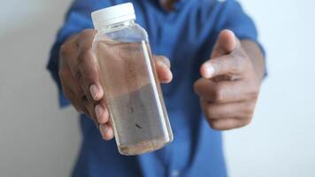 tenant une bouteille d'eau sale video